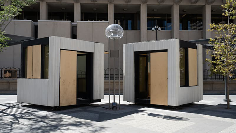 Two kiosks sitting on the sidewalk of Denver’s 16th Street Mall.
