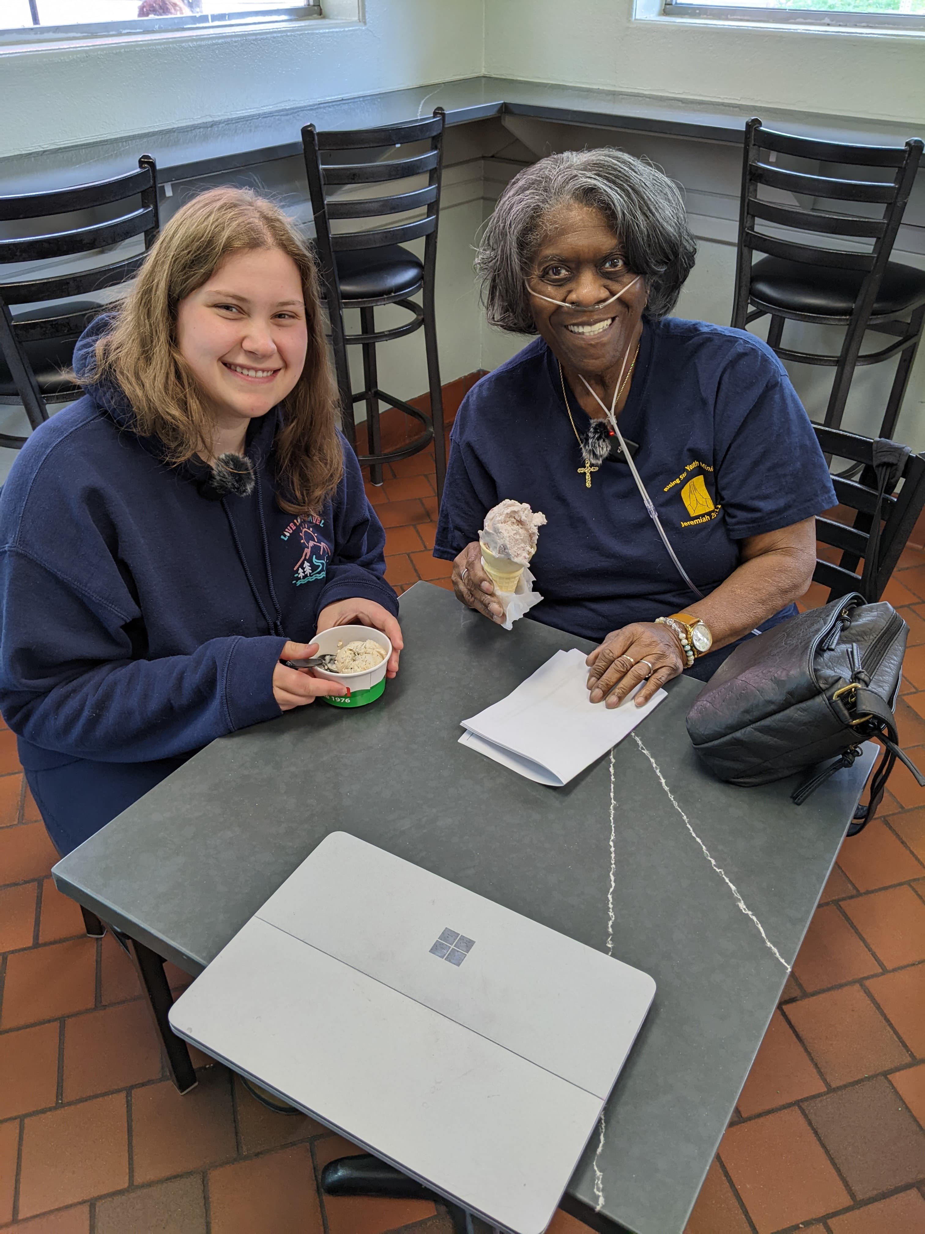 A student researcher and an older adult study participant enjoy ice cream together after completing a rideshare usability test.