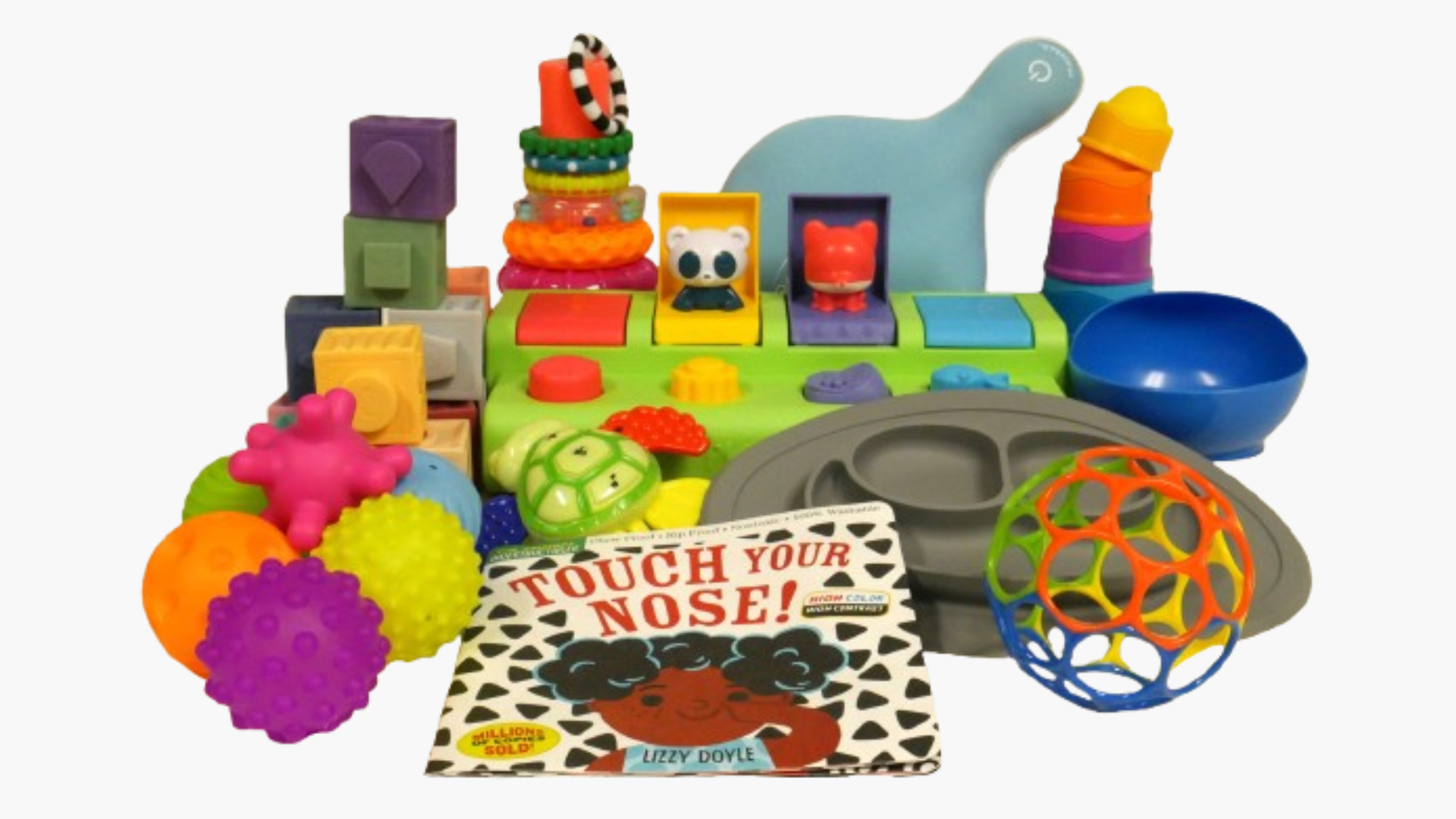 Unpacked kit with colorful toys and tools including an ezpz mat, soft building blocks, sensory balls and more