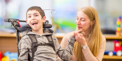 A young man in a wheelchair with his teacher