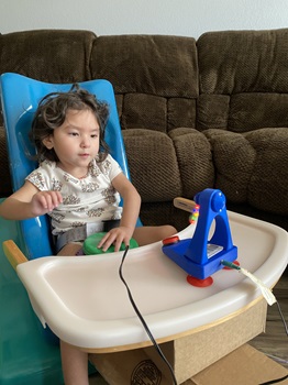 a young girl using a switch and watching the fan the switch activates