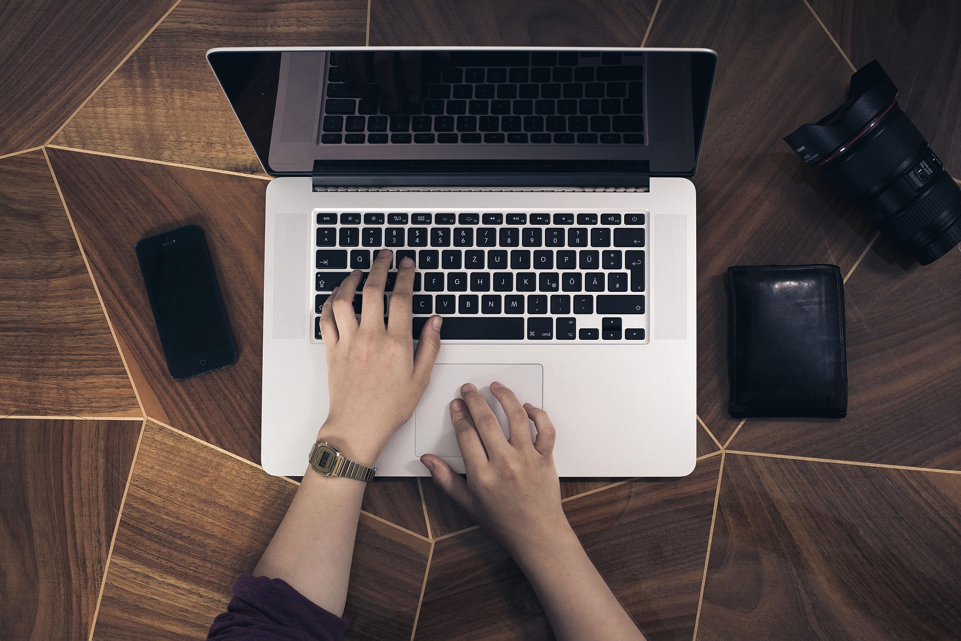 Hands typing on a laptop