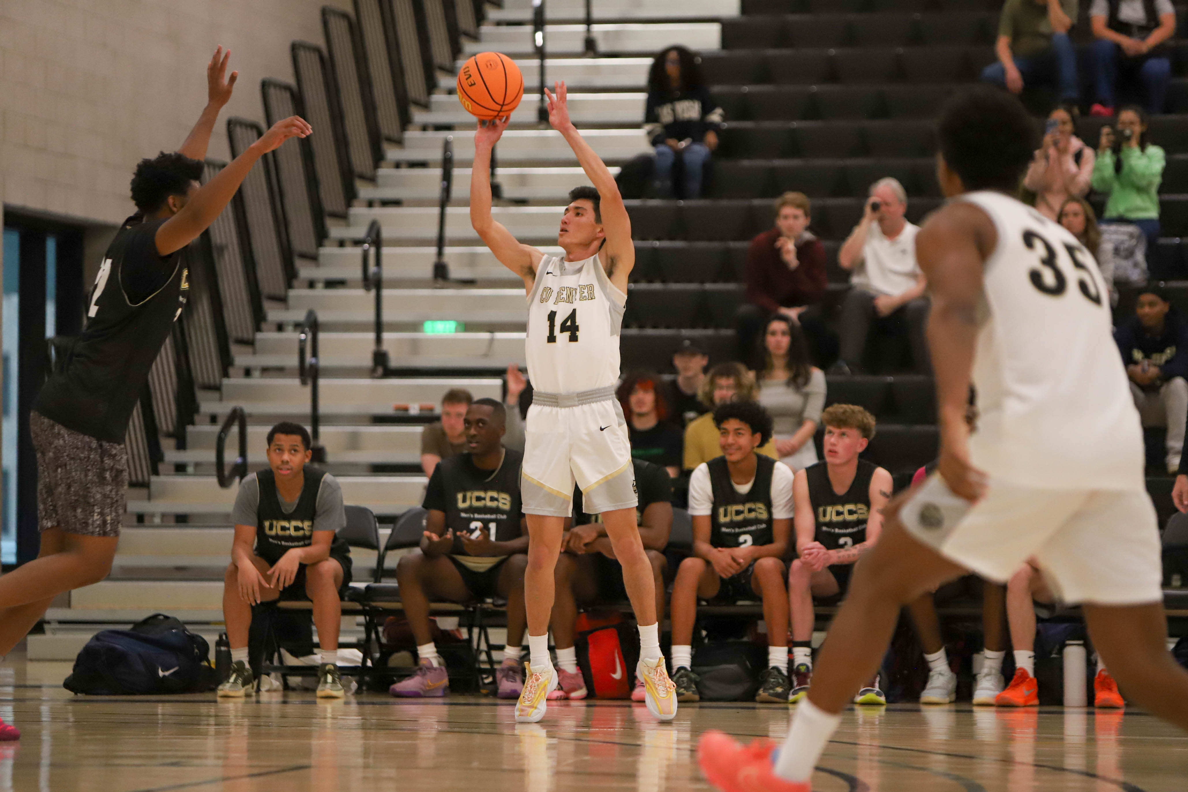 Basketball player in a white jersey shooting a ball